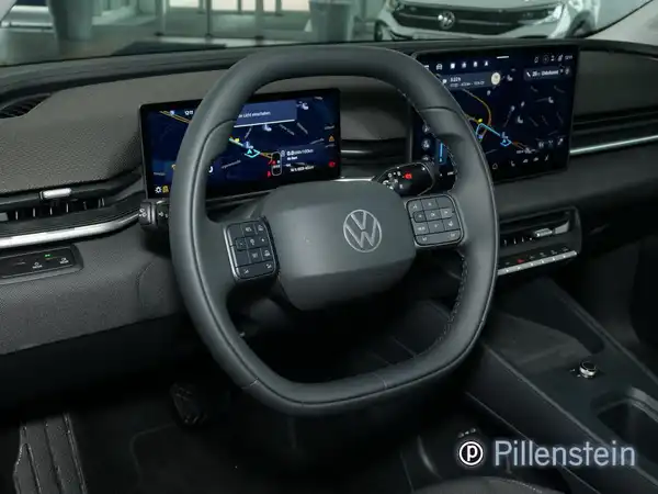 Das Bild zeigt das Innere eines VW Polo mit einem schwarzen Interieur, einschließlich des Lenkrads und zwei digitalen Displays.