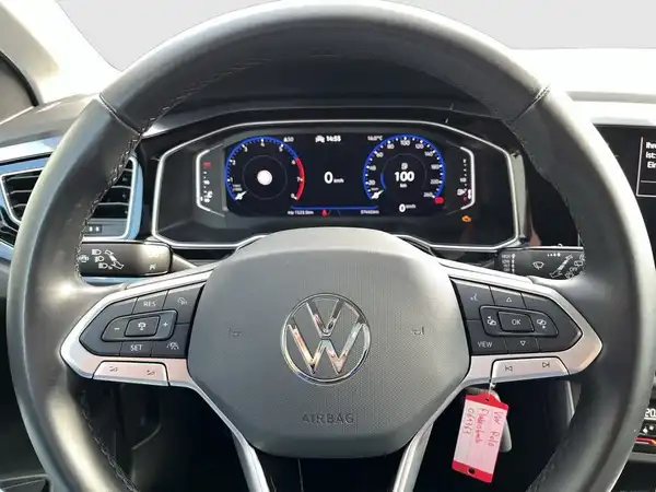 Innenaufnahme eines VW Polo mit einem schwarzen Interieur, Sicht auf das Lenkrad und Armaturen.