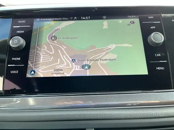 Das Bild zeigt den Innenraum eines VW Polo mit einem Blick auf das Navigationsgerät, das eine Kartenansicht anzeigt. Die Interieurfarbe ist schwarz und aus Kunststoff.