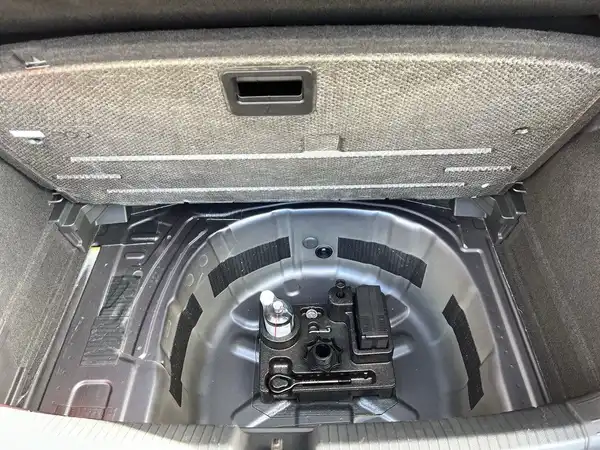 Das Bild zeigt den Kofferraum eines Fahrzeugs und bietet einen Blick auf den Reserveradbereich.