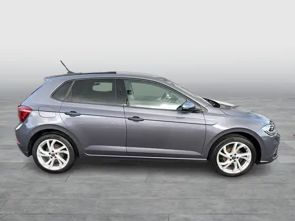 Das Bild zeigt einen grauen VW Polo von der Seite.