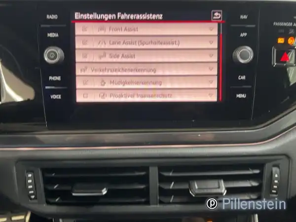 Das Bild zeigt den Innenraum eines VW Polo GTI mit einem Bildschirm, der die Einstellungen für die Fahrerassistenz anzeigt. Es gibt ein Händlerlogo auf dem Foto.