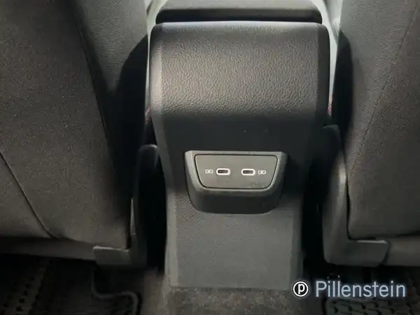 Innenaufnahme des Fahrzeugs, mit schwarzem Interieur und sichtbarem Steckdosenbereich, Händlerlogo vorhanden.
