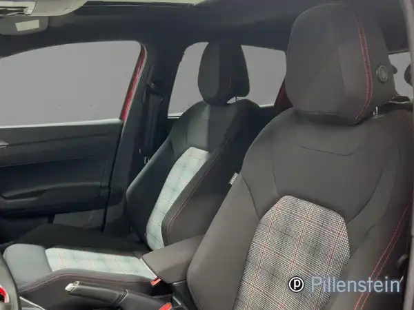 Das Bild zeigt das Innenraum eines VW Polo GTI mit schwarzen Sitzen und kariertem Muster, aufgenommen aus dem Innenraum.
