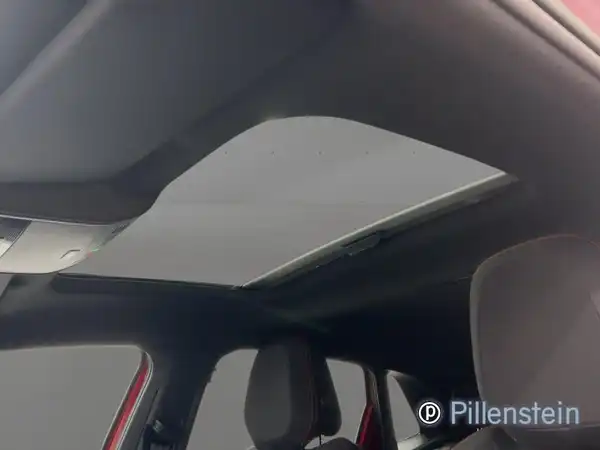 Das Bild zeigt das Innere eines VW Polo GTI mit einem Ausblick auf das Panoramadach. Die Innenfarbe ist grau und das Händlersymbol von Pillenstein ist eingeblendet.