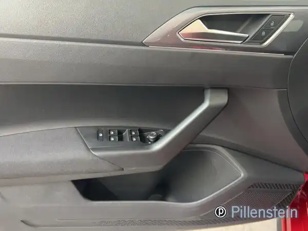 Das Bild zeigt die Innenansicht der Fahrertür eines VW Polo GTI. Die Türverkleidung ist schwarz und es gibt markante Bedienelemente für Fenster und Spiegel. Das Händlerinformationslogo "Pillenstein" ist auf dem Bild zu sehen.
