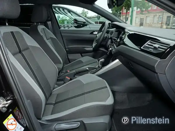 Innenaufnahme des Fahrzeugs VW Polo mit schwarzen und grauen Sitzen.