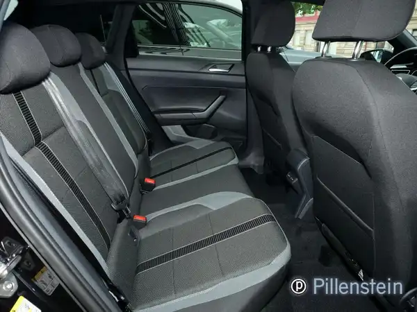 Das Bild zeigt den Innenraum des Volkswagen Polo, speziell die Rücksitze in schwarz mit grauen Akzenten. Es ist ein Händlerlogo sichtbar.
