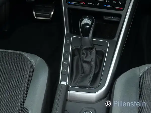 Fahrzeuginnenraum mit Schaltknauf und Sitzen in schwarz und grau, Händlerlogo ist sichtbar.