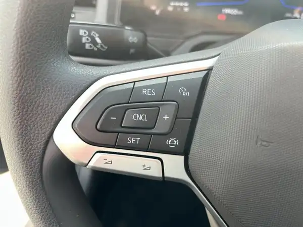 Aufnahme des Fahrzeuginnenraums, speziell vom Lenkrad und den Bedienknöpfen eines VW Polo in schwarzer Farbe.