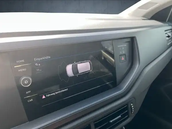 Das Bild zeigt das Innere eines VW Polo mit einem schwarzen Interieur. Es ist eine Aufnahme des Infotainment-Systems, das verschiedene Optionen anzeigt.