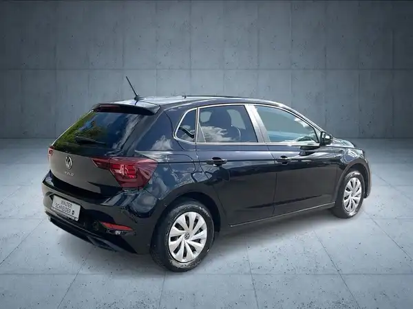 Das Bild zeigt einen schwarzen VW Polo von hinten, aufgenommen in einer Studio-Umgebung.