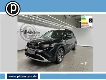 Das Bild zeigt einen schwarzen VW T-CROSS von der Seite in einem Ausstellungsraum. Das Händlerlogo von Pillenstein ist sichtbar, sowie einige markante Texteinblendungen über dem Fahrzeug.