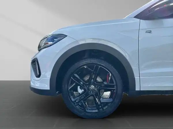 Seitenansicht eines weißen VW T-Cross mit Fokus auf dem Rad und der Karosserie.