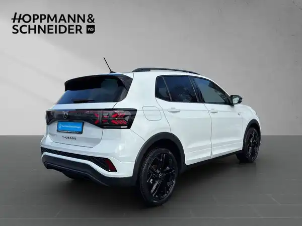Das Bild zeigt einen VW T-CROSS in weißer Farbe von der Seite, mit dem Logo des Händlers HOPPMANN & SCHNEIDER im Bild.