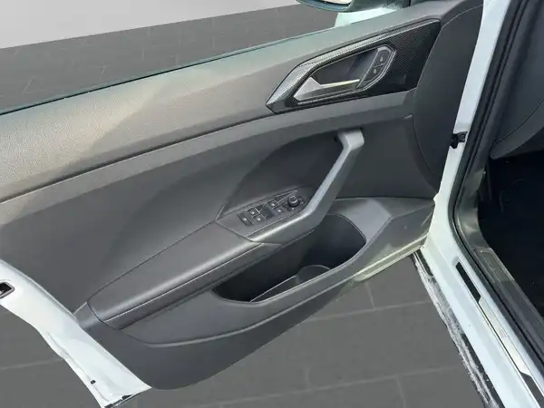 Das Bild zeigt die Innenseite der Fahrertür eines VW T-Cross in weiß mit dunklem Interieur.