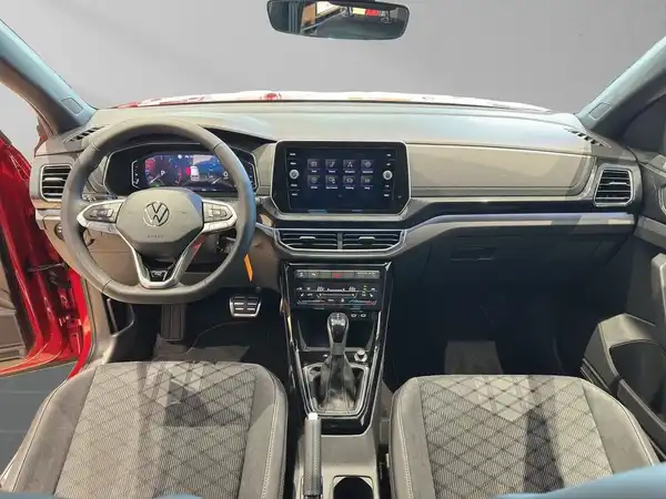 Ein Innenraumfoto eines VW T-Cross, mit einem schwarzen Interieur und karierter Musterung auf den Sitzen.