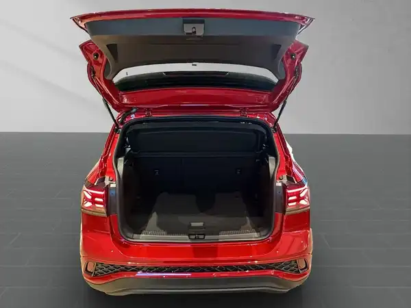 Das Bild zeigt den hinteren Kofferraum eines roten VW T-Cross mit geöffnetem Heck.