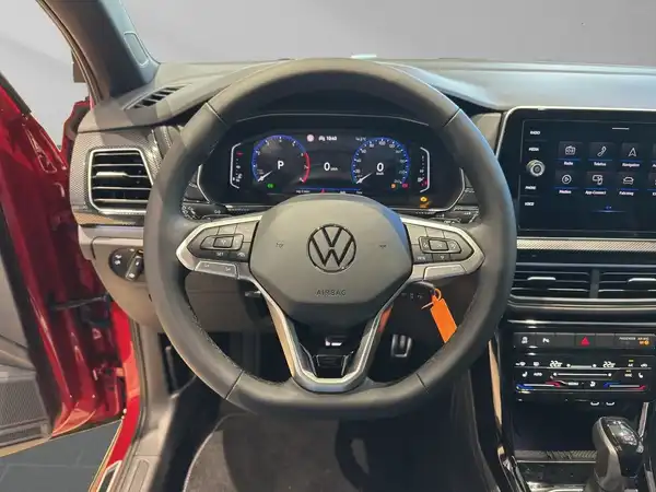 Das Bild zeigt das Innere eines Volkswagen mit einem schwarzen Armaturenbrett und einem Sportlenkrad.