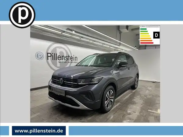 Das Bild zeigt einen grauen VW T-CROSS aus der Frontansicht. Im Hintergrund ist das Händlerlogo von Pillenstein zu sehen und es gibt markante Texteinblendungen.