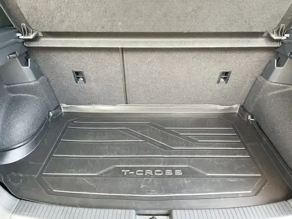 Das Bild zeigt den Innenraum des Kofferraums eines VW T-CROSS. Der Kofferraumboden ist schwarz und trägt die Prägung "T-CROSS".