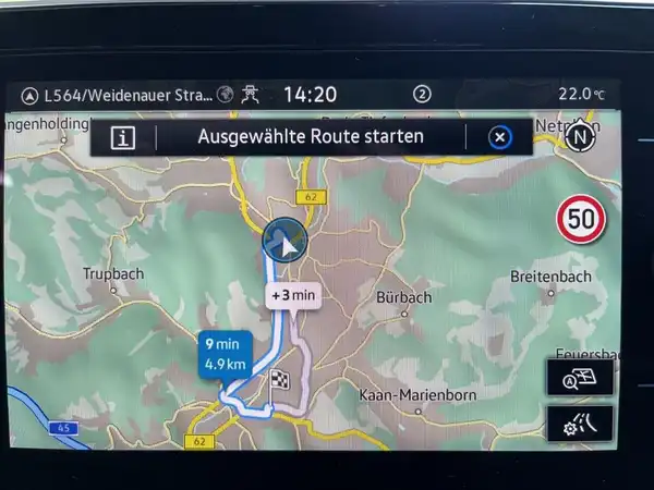 Das Bild zeigt die Darstellung eines Navigationsgeräts im Fahrzeug, mit einer Karte und Route.