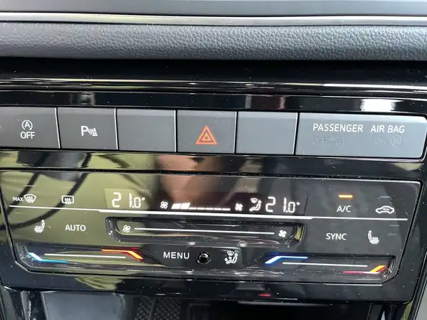 Das Bild zeigt das Armaturenbrett eines VW T-CROSS mit Bedienelementen für Klimaanlage und Audio, in schwarzer Innenausstattung.