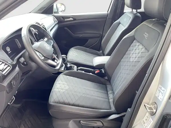Das Bild zeigt den Innenraum eines VW T-CROSS mit schwarzen Sitzen.