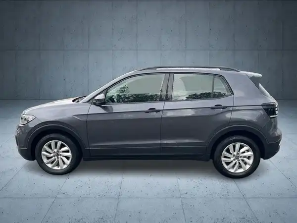 Das Bild zeigt einen grauen VW T-CROSS von hinten. Es ist ein Fahrzeugbild, auf dem Händlerlogo sichtbar ist.
