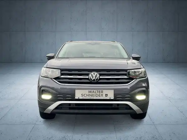 Das Bild zeigt einen grauen VW T-CROSS aus der Frontalansicht, mit dem Händlernamen 'WALTER SCHNEIDER' im Vordergrund.