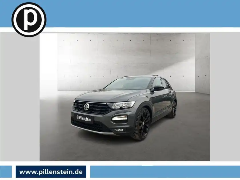 Das Bild zeigt einen schwarzen VW T-Roc von vorne, mit dem Händlerlogo von Pillenstein im unteren Bereich.