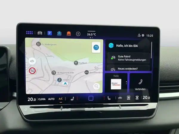Das Bild zeigt das Innere eines Fahrzeugs mit einem Display, das Informationen wie Navigation und Fahrzeugstatus anzeigt. Die Innenfarbe ist schwarz und es sind markante Texteinblendungen vorhanden.