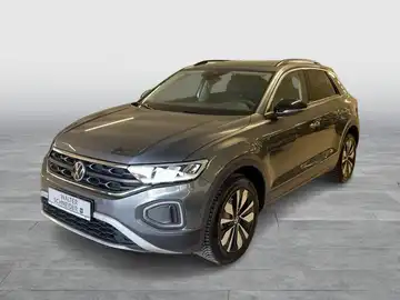 Das Bild zeigt einen grauen VW T-Roc, aufgenommen von vorne. Es gibt ein Händlerlogo sowie markante Texteinblendungen.