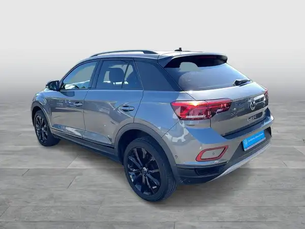 Das Bild zeigt einen VW T-ROC von der Seite in grauer Farbe.