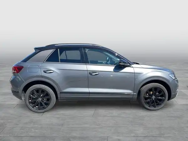 Das Bild zeigt einen grauen VW T-ROC von der Seite.