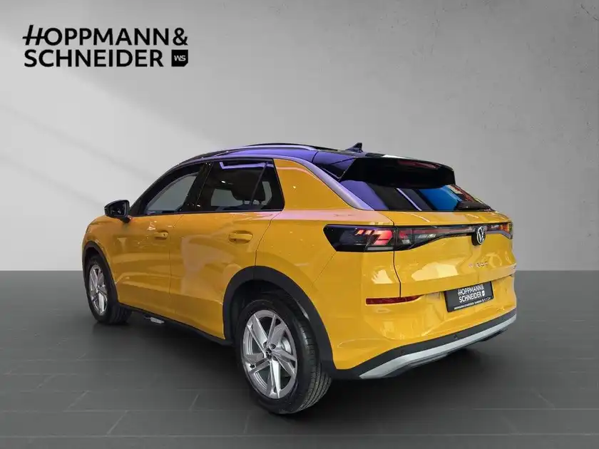 Das Bild zeigt einen VW T-ROC in gelber Farbe von hinten mit dem Händelrlogo HOPPMANN & SCHNEIDER.