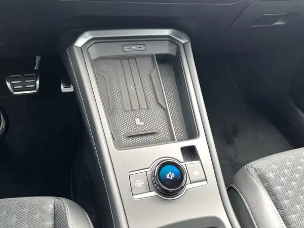 Das Bild zeigt den Innenraum eines Fahrzeugs, insbesondere das Armaturenbrett mit einem zentralen Bedienelement in schwarz.