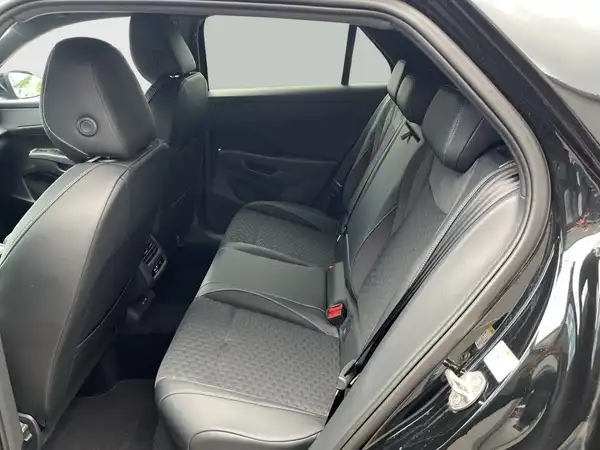 Das Bild zeigt den Innenraum eines VW T-ROC mit einer schwarzen Rückbank und einer Innenausstattung in Schwarz.