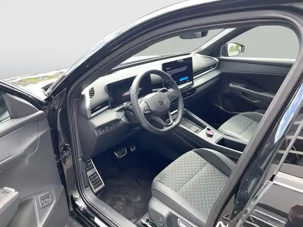 Das Bild zeigt die Innenaufnahme eines VW T-Roc in schwarzem Farbton mit grauen Sitzen und geometrischem Muster.