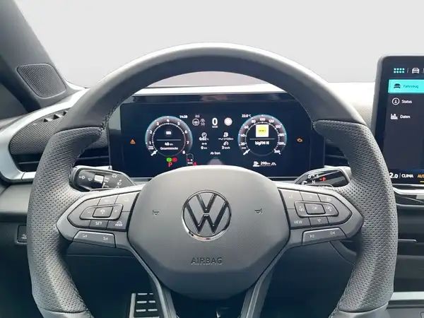 Das Bild zeigt das Interieur eines VW T-ROC mit einem schwarzen Lenkrad und Armaturenbrett. Die Anzeige im Dashboard ist gut erkennbar.
