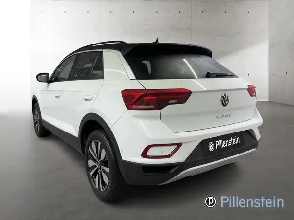 Das Bild zeigt einen Volkswagen T-Roc von hinten in weißer Farbe. Das Händlerlogo "Pillenstein" ist auf dem Foto eingeblendet.