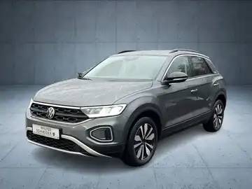 Das Bild zeigt einen grauen VW T-ROC von vorne mit dem Händlerlogo im unteren Bereich.