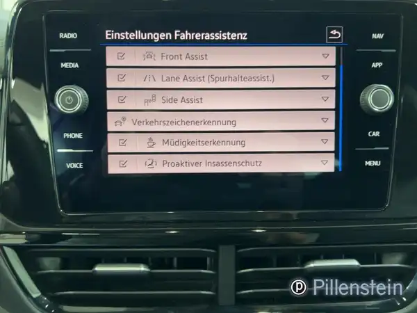 Das Bild zeigt das Innenleben eines Fahrzeugs, konkret das Armaturenbrett mit einem schwarzen Interieur. Auf dem Bildschirm sind verschiedene Menüs zu sehen. Ein Händlerlogo ist vorhanden und erkennbare Texteinblendungen sind sichtbar.