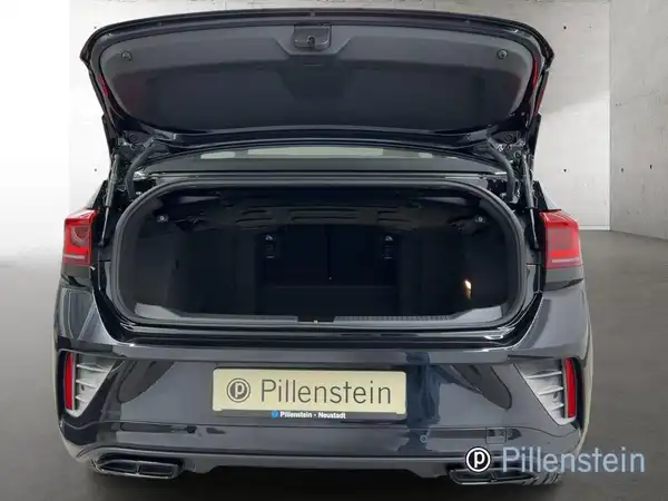 Das Bild zeigt den offenen Kofferraum eines schwarzen Fahrzeugs, aufgenommen von hinten. Das Händlerlogo "Pillenstein" ist sichtbar.