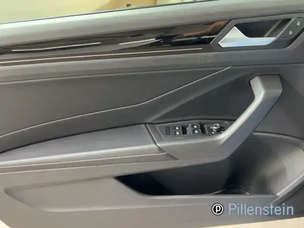 Das Bild zeigt die Innenansicht der Fahrertür eines VW T-ROC Cabriolet in schwarzer Farbe.