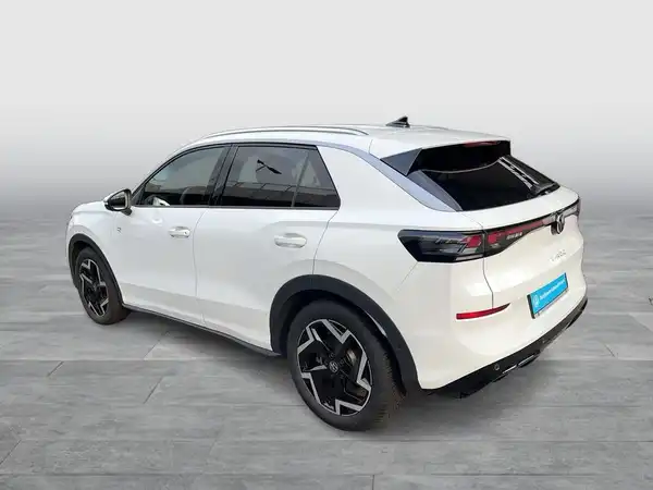Das Bild zeigt einen weißen VW T-ROC, aufgenommen von der Seite.