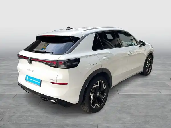 Das Bild zeigt einen weißen VW T-ROC aus der Rückansicht. Es handelt sich um ein Fahrzeugbild.