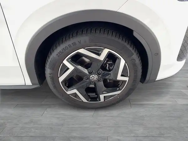 Das Bild zeigt die Seite eines weißen VW T-ROC mit einem Blick auf die Felge und den Reifen.