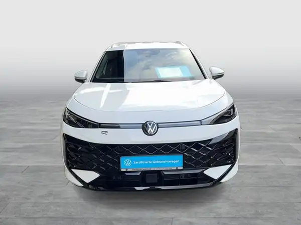 Das Bild zeigt einen weißen VW T-ROC von vorne. Am unteren Rand ist das Händlerlogo sichtbar.