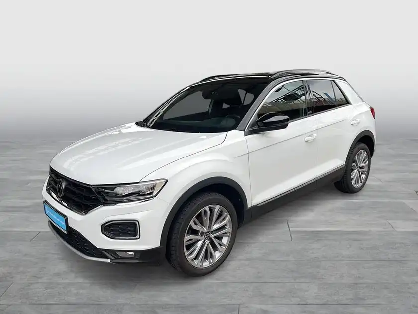 Das Bild zeigt einen weißen VW T-ROC, aufgenommen von der Seite.